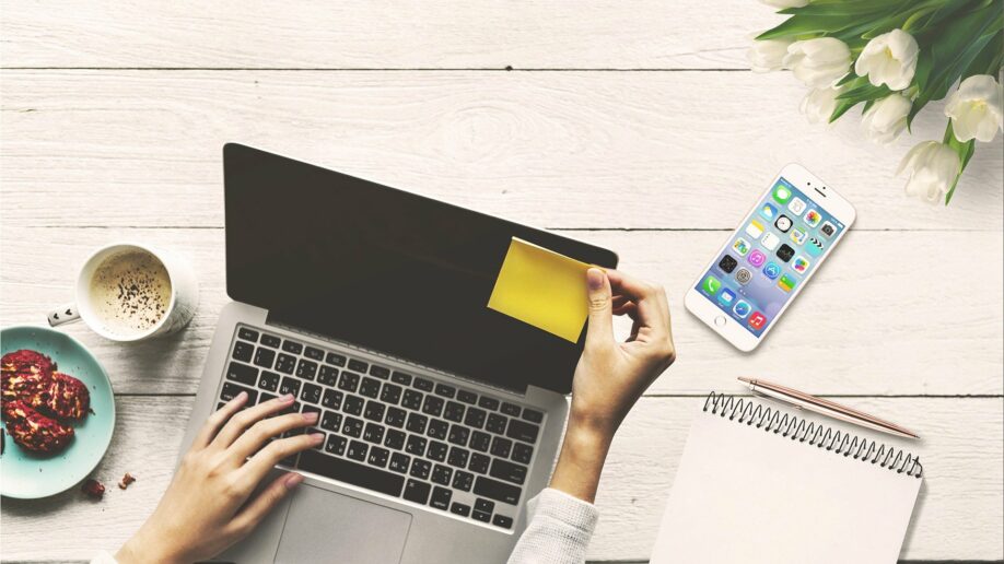 Компьютер, ноутбук, мобильный телефон, плата, текст, чашка, кредитная карта на столе.