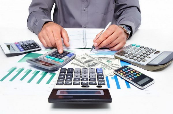 Электроника: мужчина с мобильным телефоном, калькулятором, пультом и ручкой.