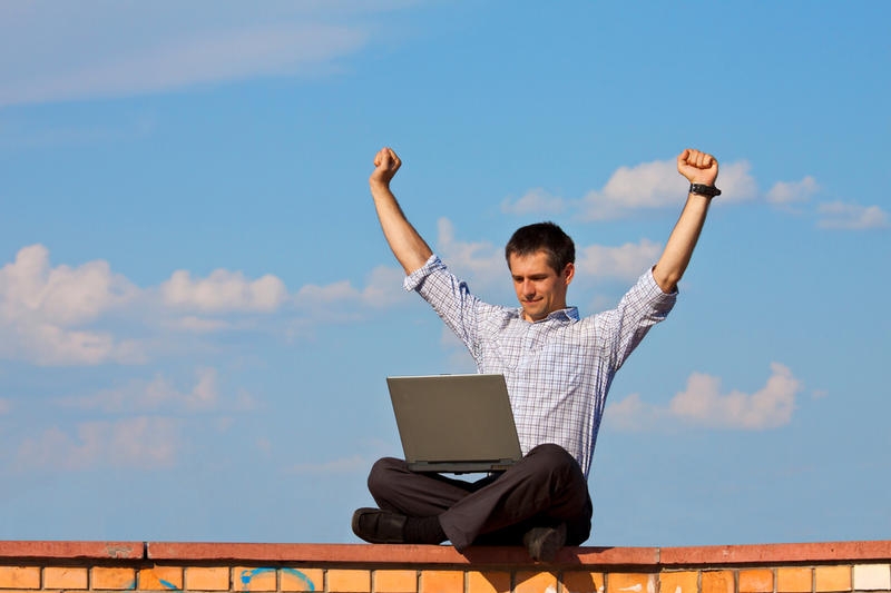 Голова счастливого мужчины с ноутбуком и туфлей, лицо выражает победу.