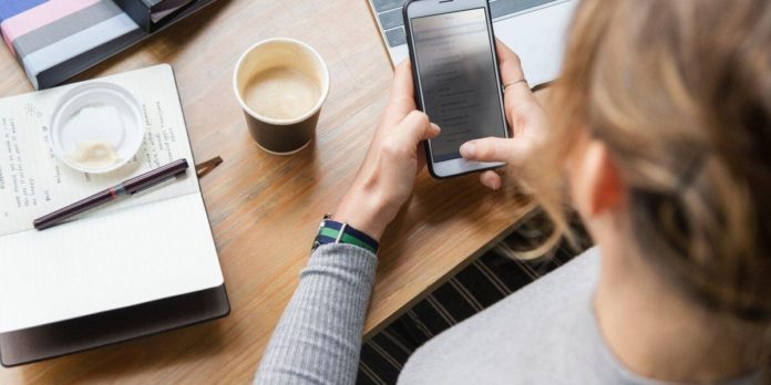 Электроника: женщина с мобильным телефоном, читает сообщение.