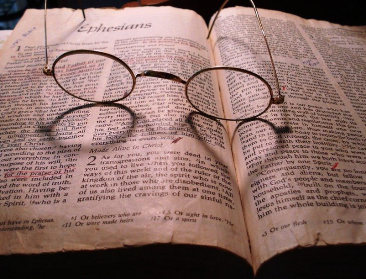 Аксессуары человека: очки, книга с открытой страницей, текст, чтение.