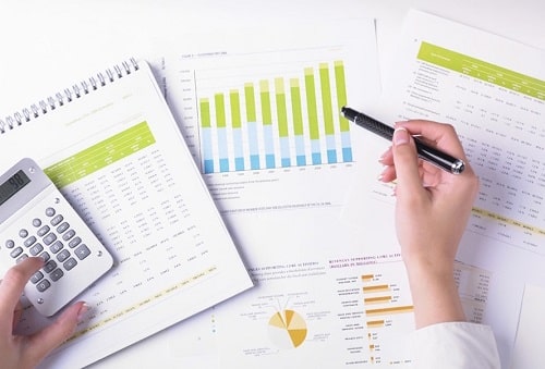 Человек с ручкой у книги, публикации и графика.