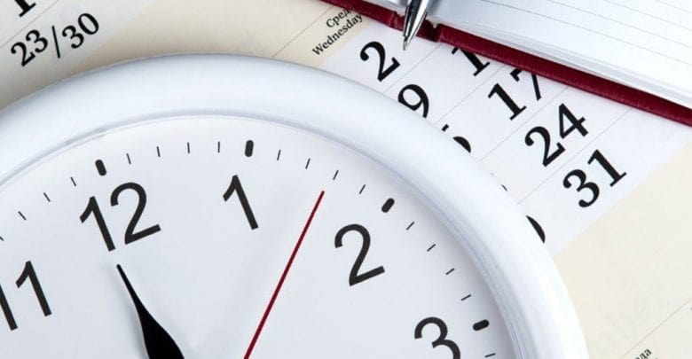 Аналоговые часы с тремя стрелками и текстом на циферблате.