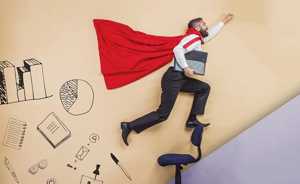 Взрослый мужчина стоит на улице, в фоне видны дома.