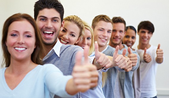 Младенец держит папин палец рукой, лицо ребенка и часть тела видны.