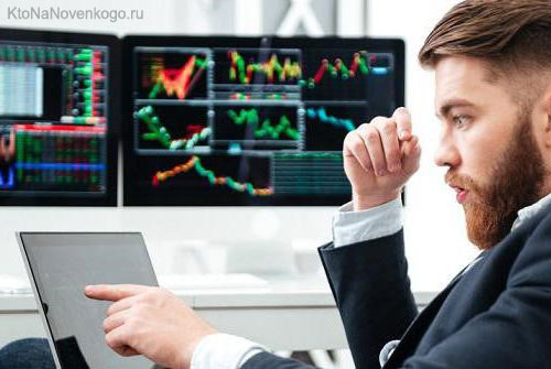 Взрослый мужчина смотрит на монитор компьютера с электроникой вокруг него.