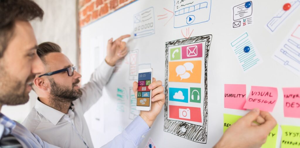 Взрослый мужчина с красивым лицом, стоящий у белой доски.