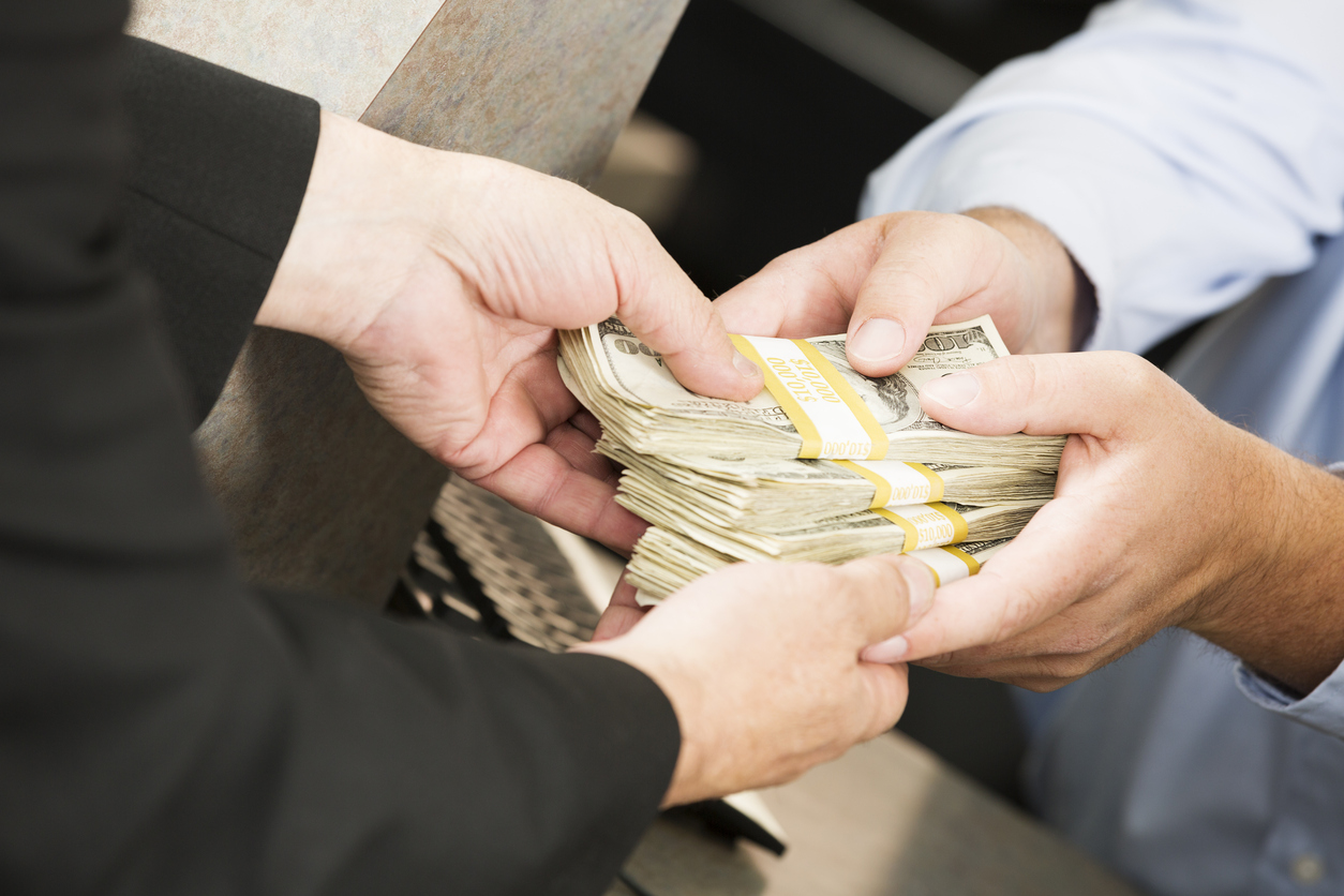 Человек с деньгами на руке, показывает палец.