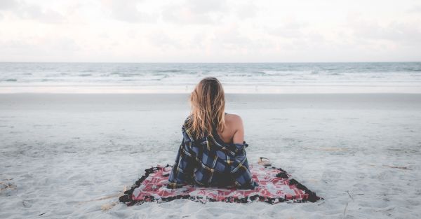 Покрывало на пляже, фон природы с видом на море и песчаный берег.