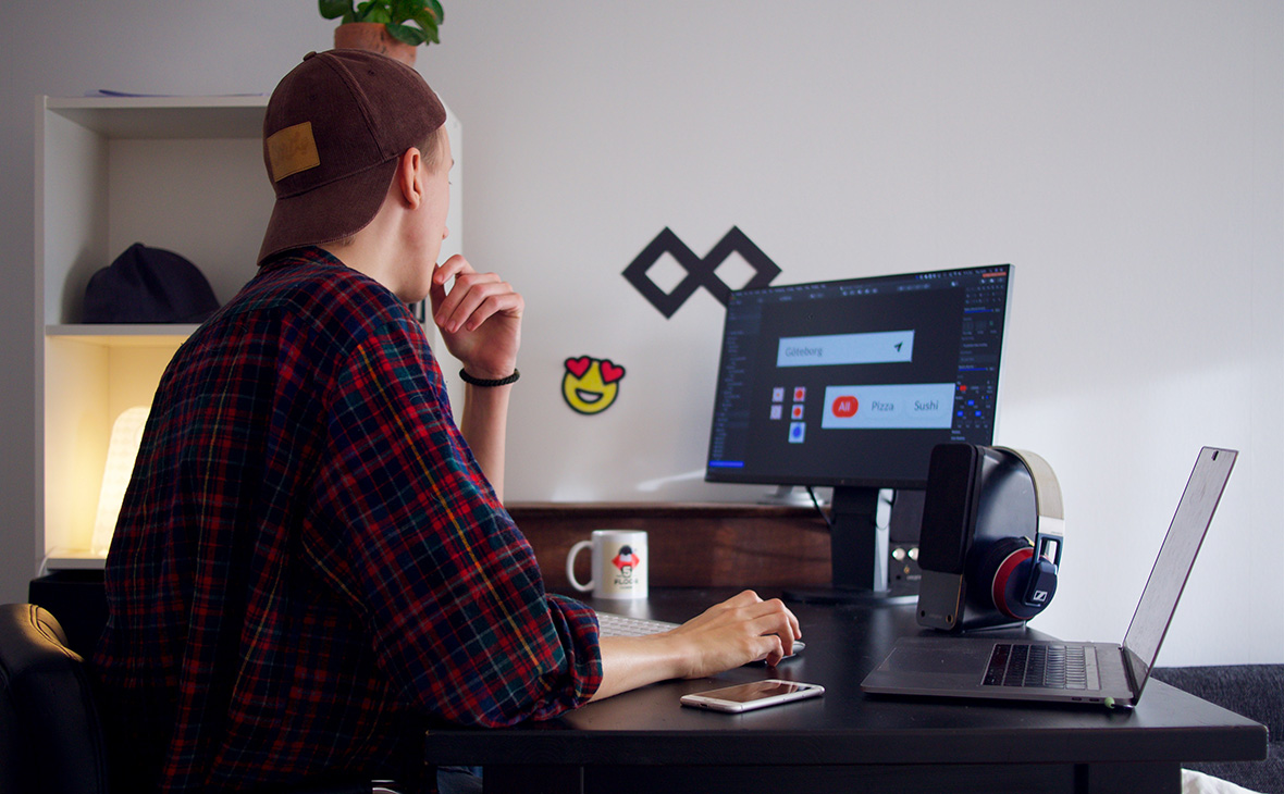 Мужчина за компьютерным столом с монитором и ноутбуком. Пк и компьютерное оборудование.