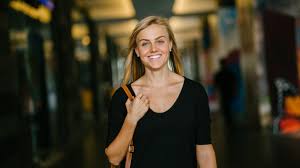 Счастливый блондин с улыбкой на лице дымом из трубки на фоне фотографии.