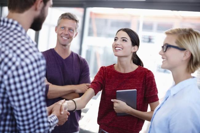 Человек счастливо улыбается во время разговора, лицо и голова видны.