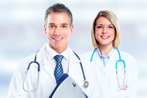 Мужчина в лабораторном халате с галстуком и очками, женщина рядом.