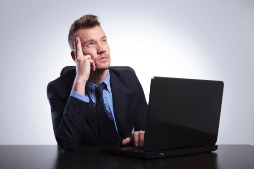 Мужчина в галстуке у компьютера, выражение лица сосредоточенности, ноутбук, ПК.