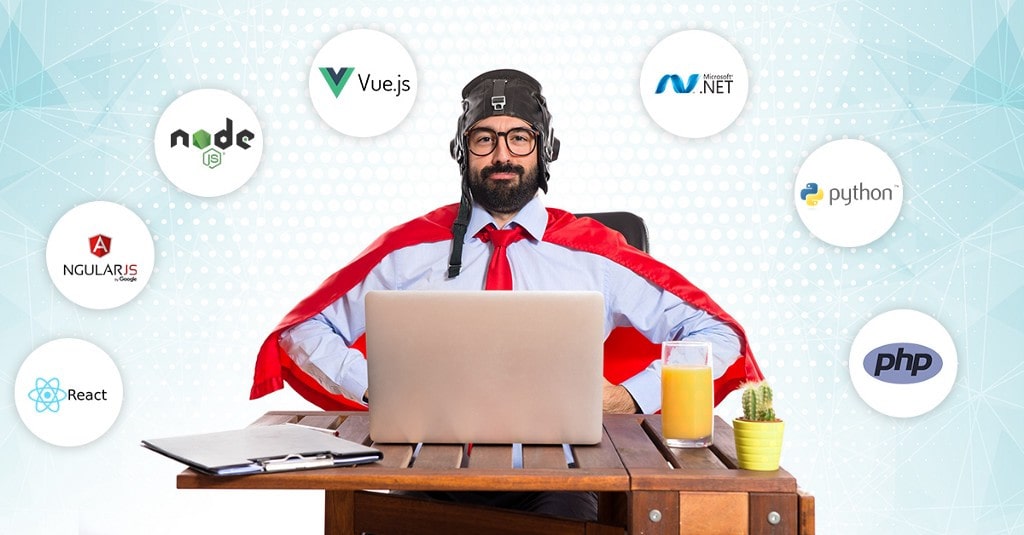 Взрослый мужчина в галстуке работает за ноутбуком в офисе с растением и чашкой.