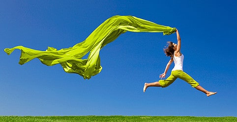 Человек на траве рядом с растением.