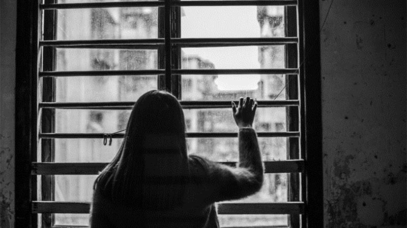 Женская рука на окне домашнего декора, взгляд в даль сквозь решетку.