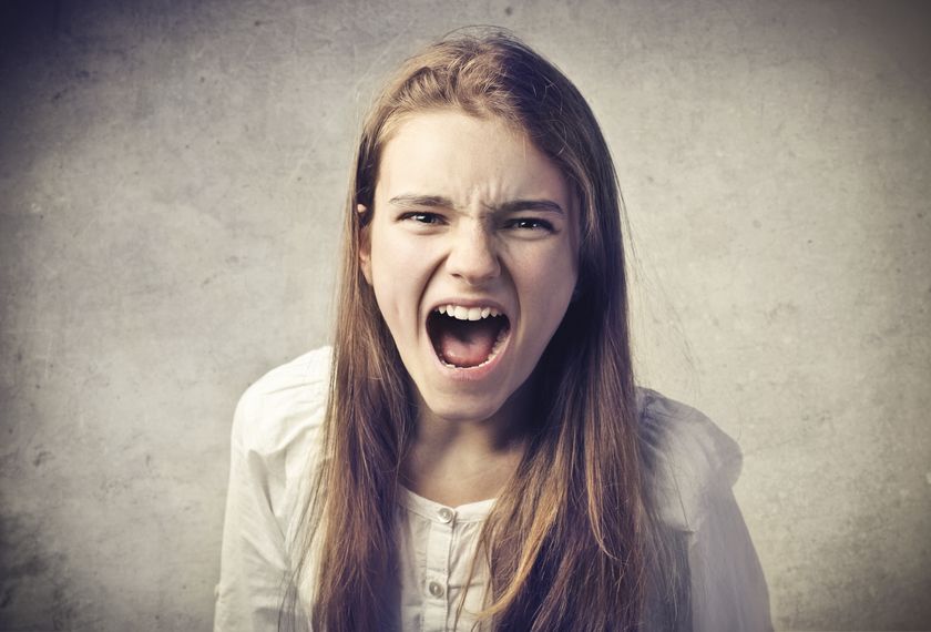 Человек с сердитым выражением лица кричит, демонстрируя негодование.