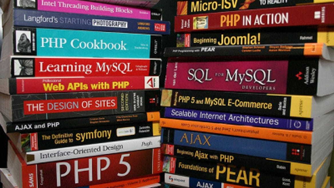 Книга в библиотеке: человек читает публикацию внутри помещения.