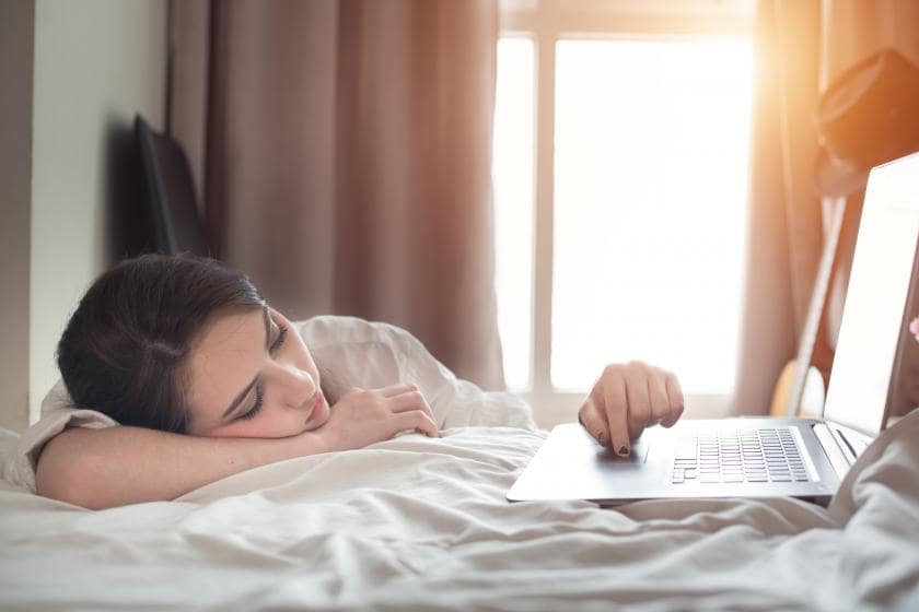 Женщина-взрослая сидит за ноутбуком, фокус на лице.