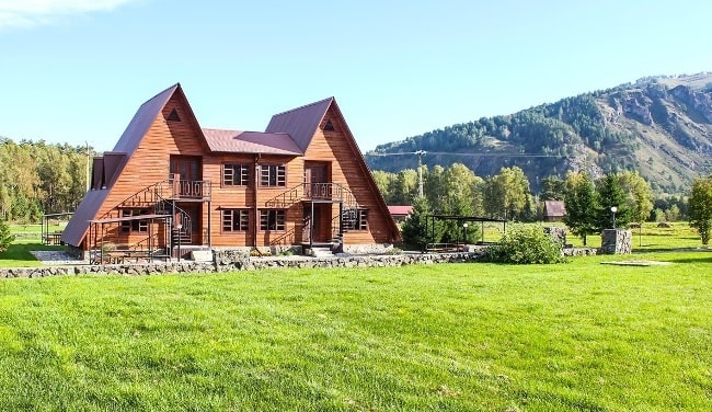 Архитектура деревянного коттеджа с окружающей природой на заднем плане.