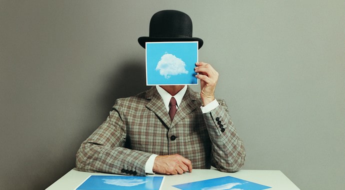 Фотография мужчины с головой, лицом и шляпой, за столом в офисе.