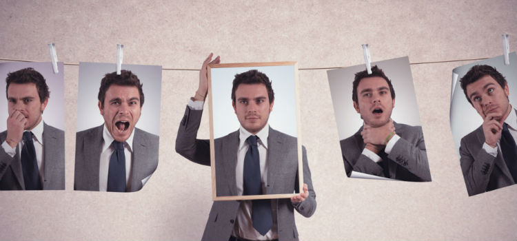 Мужчина в деловом костюме с галстуком, сосредоточенно смотрит в камеру.