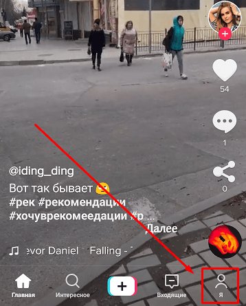 Женщина с сумкой идет по городской улице, держа в руке мобильный телефон.