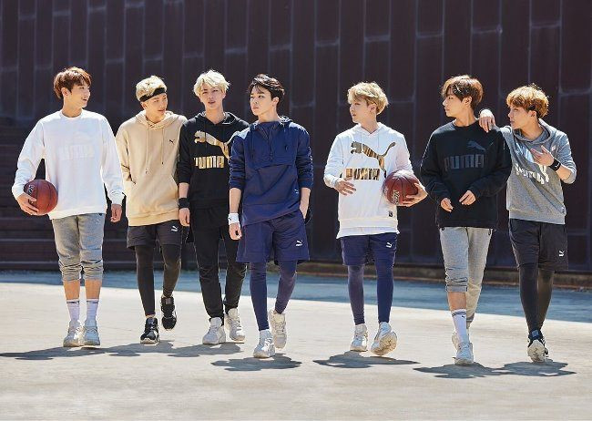 Групповое фото молодых людей, парень в шортах и свитере, играют в баскетбол.