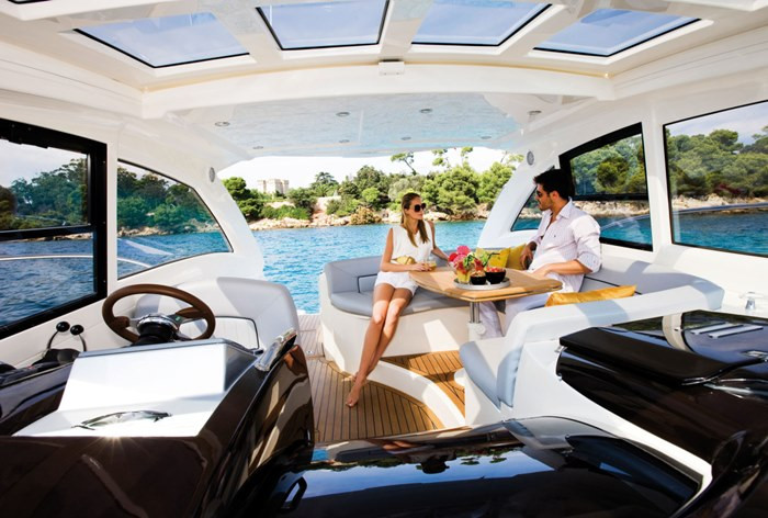 Мужчина в коротких шортах за столом на яхте с колесом.