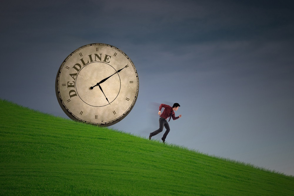 Человек гуляет по полю с травой, аналоговые часы на траве.