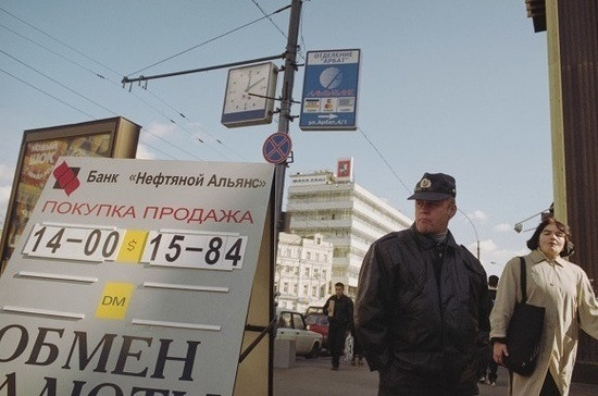 Мужчина и женщина в городе, одетые в пальто и куртку, несущие сумки.