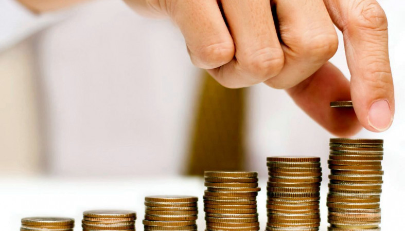 Денежная монета на пальце руки человека - тема фотографии.