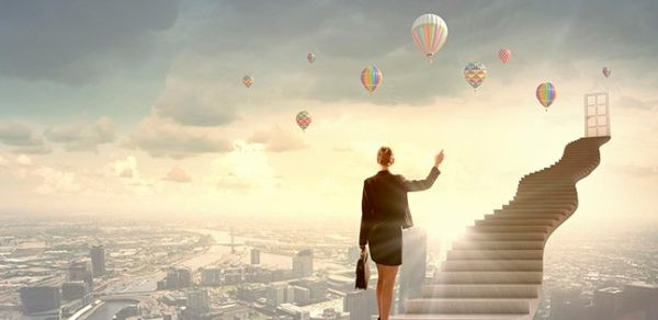 Женщина в городе с воздушным шаром на фоне голубого неба.