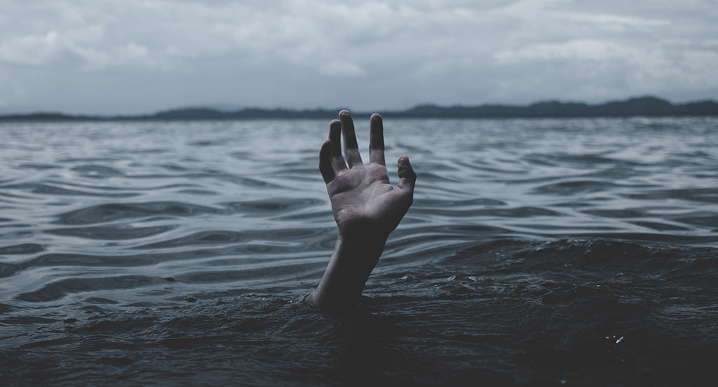 Человек, находящийся на улице, показывает пальцем на руке.