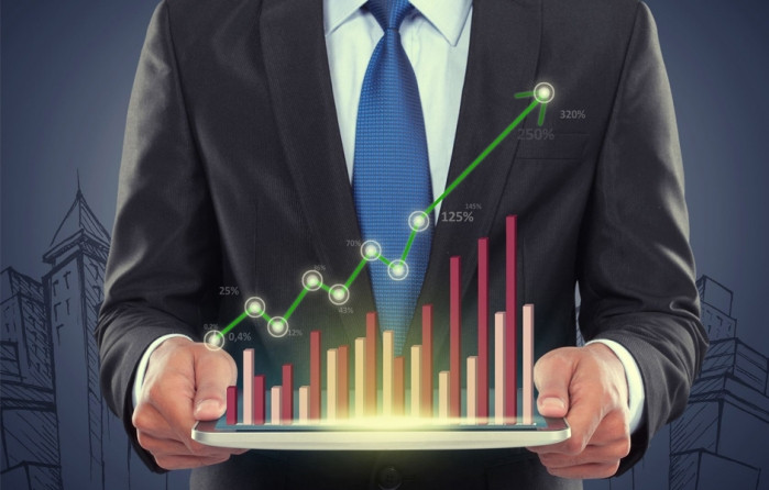 Мужчина в деловом костюме с галстуком, рядом столбчатая диаграмма.