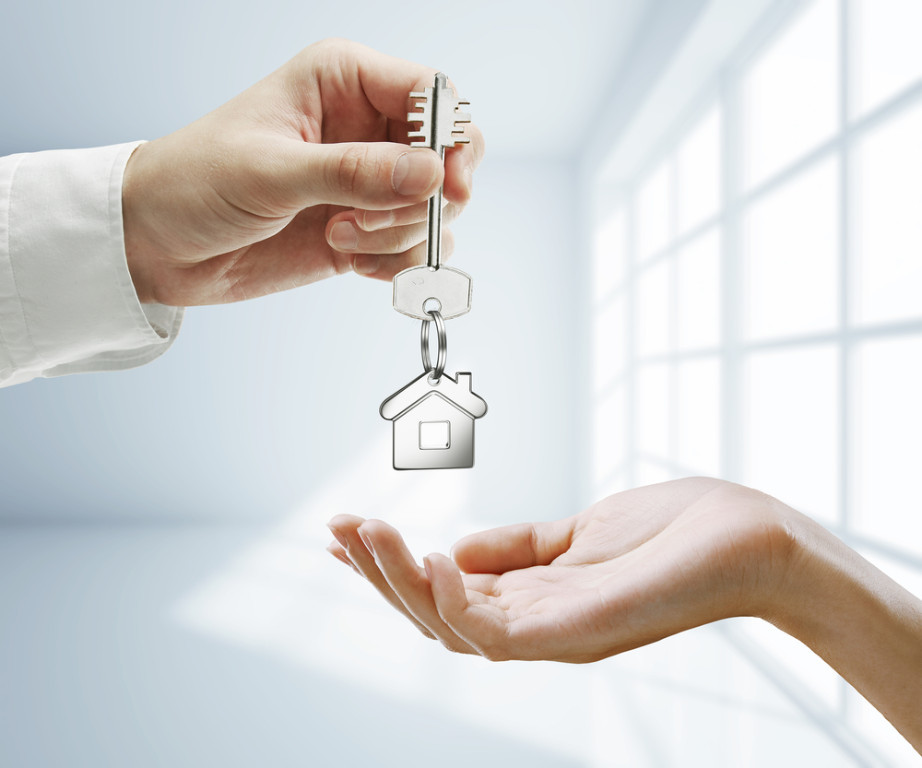 Ключевое изображение: серебряный ключ на фоне деревянного стола.