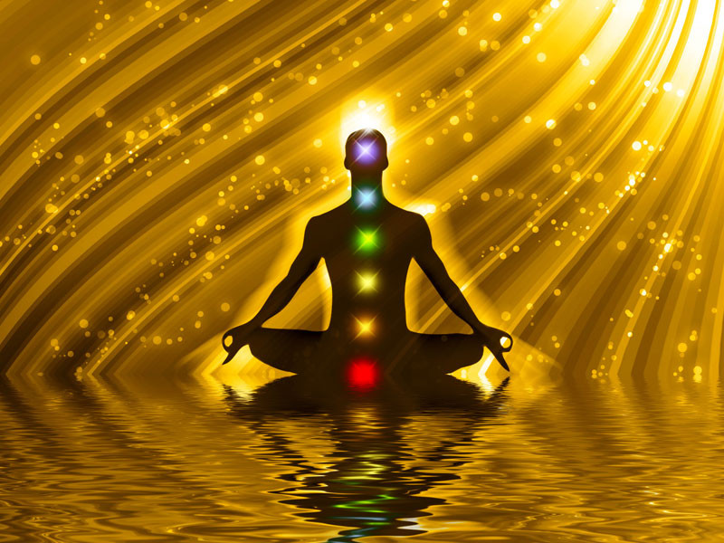 Взрослый мужчина стоит на берегу воды, окруженный светом на открытом воздухе.