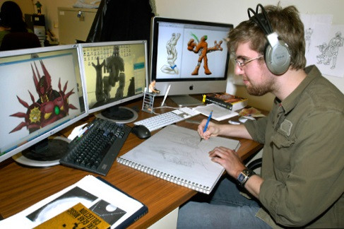 Женщина в наушниках за компьютером с монитором, клавиатурой и ручкой.