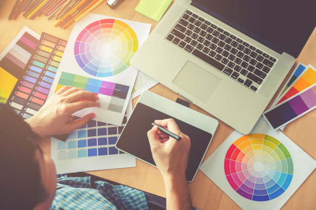 Ноутбук и мобильный телефон на столе с клавиатурой, электроникой и человеком.