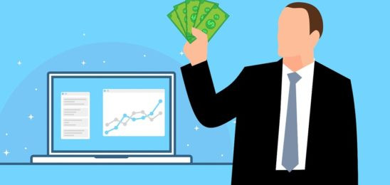 Взрослый мужчина в офисной одежде с галстуком, работающий за компьютерным экраном.