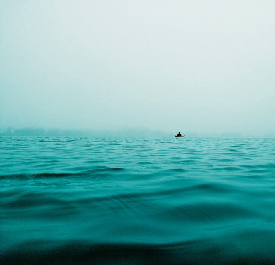 Плавание на фоне морского пейзажа с парусником, горизонтом и небом.