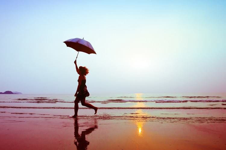 Парящий на берегу пляжа человек сфотографирован при прогулке по побережью моря.