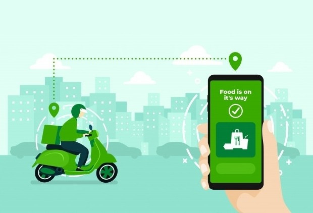 Снимок человека, который едет на скутере с телефоном в городе.