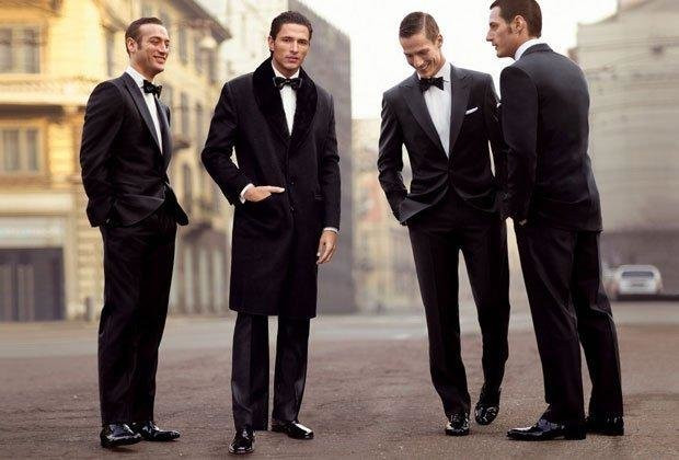 Мужчины в офисных костюмах и пиджаках идут впереди в групповой съемке.