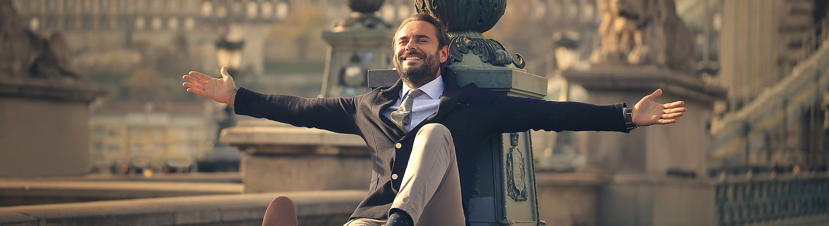 Городской исполнитель в костюме, улыбающийся лицом, указывающий пальцем вперед.