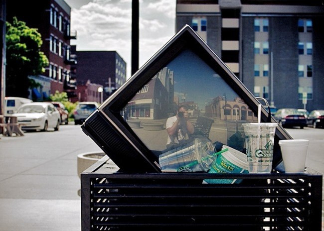 Электроника, монитор на улице города, персона на урбанистическом фоне.