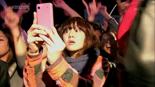 Фото человека смартфоне в руке, делающего снимок себя.