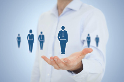 Одетое лицо в длинный рукав футболки и пальто, держащее руку.