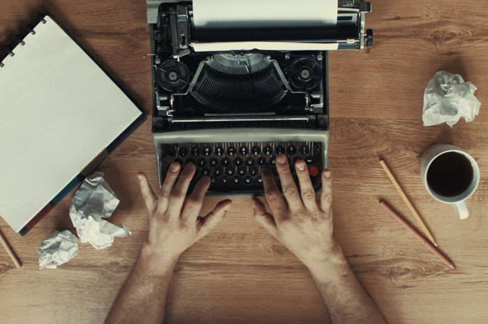 Человек использует компьютер на столе в офисе с клавиатурой.